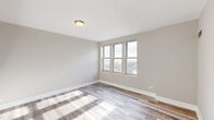 Located on the 8th floor at 10 N Sheridan Road in Waukegan, Illinois, this one-bedroom, one-bathroom residence offers a well-organized layout with modern finishes throughout. Light wood-style flooring runs continuously across the living areas, complementing the neutral, warm-toned walls that create a clean and cohesive aesthetic.

The kitchen is thoughtfully designed with rich warm-toned cabinetry extending to the ceiling for ample storage, light granite countertops, and a full suite of appliances including a refrigerator, electric range, and over-the-range microwave. A pass-through counter connects the kitchen to the open living area, enhancing the sense of space and facilitating easy interaction between rooms.

The living area is bright and open, benefiting from natural light and providing direct access to a private balcony through a sliding glass door. The balcony features decorative wrought iron railings and offers open outdoor views of the surrounding landscape.

The bedroom is a comfortable size, featuring a bank of windows that frame expansive outdoor views and flood the room with natural light. The bathroom is appointed with large-format travertine-style wall tiles surrounding a soaking jetted tub, adding a touch of elegance to the space. Overall, this residence presents a practical and attractive living environment with thoughtful details throughout.