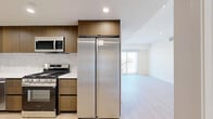 Located at 1339 Tamarind Ave in the heart of Hollywood, Los Angeles, this modern unit offers 4 bedrooms and 4 bathrooms across a single floor. The space features a clean, contemporary design throughout, with light wood-tone flooring and crisp white walls that create a bright, cohesive aesthetic.

The kitchen is well-appointed with warm wood cabinetry, white quartz countertops, a subway tile backsplash, and a full suite of stainless steel appliances including a gas range, over-the-range microwave, dishwasher, and a large French door refrigerator. Recessed lighting adds a polished finish.

Each of the four bedrooms is generously proportioned with clean lines, recessed lighting, and ample closet space — several featuring sleek mirrored sliding closet doors. Select bedrooms open directly to city views through large sliding glass doors, flooding the rooms with natural light. The primary bedroom includes an en-suite bathroom and access to outdoor views of the surrounding Los Angeles skyline.

The four bathrooms maintain a consistent modern aesthetic, featuring wood-toned vanities with white countertops, large mirrors, light tile flooring, and glass-enclosed showers. Two hallways connect the rooms efficiently, contributing to a well-organized, functional layout ideal for shared or multi-occupant living.