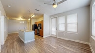 Located at 7803 South New Braunfels Avenue in San Antonio, TX, this single-story, 2-bedroom, 2-bathroom home offers a well-designed open-concept layout with modern finishes throughout. The living and dining area features warm wood-look flooring, a ceiling fan, and large windows with blinds that allow ample natural light, with a patio door providing outdoor access.

The galley-style kitchen is equipped with warm wood cabinetry, granite countertops, black appliances including a range, microwave, refrigerator, and dishwasher, as well as a double basin sink and pendant lighting overhead. A kitchen island with additional counter space and storage connects seamlessly to the living area.

Both bedrooms are carpeted, with ceiling fans and multiple windows that bring in natural light. The spacious primary bedroom includes its own closet, and the home features a total of three closets for generous storage. Both bathrooms are finished with wood cabinetry, granite countertops, subway tile tub-and-shower surrounds, and wood-look flooring.

Additional spaces include a dedicated utility room and a patio. The home's neutral color palette, consistent finishes, and functional floor plan make it a practical and comfortable residence in San Antonio.