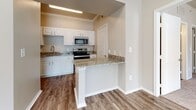This single-floor residence offers a thoughtfully designed layout that balances functionality with comfort. The kitchen is a standout feature, showcasing white raised-panel cabinetry, granite countertops, and stainless steel appliances including a range and built-in microwave. A peninsula with a matching granite surface extends into the adjacent area, providing additional prep space and a natural transition between the kitchen and living spaces. Durable hardwood-style flooring runs throughout the kitchen and adjoining rooms, adding warmth and easy maintenance.

The living spaces are bathed in natural light, courtesy of large windows dressed with blinds that allow for adjustable brightness. Soft, plush carpeting underfoot lends a cozy feel to the bedroom areas, while ceiling fans ensure year-round comfort. Crown molding in select rooms adds an elegant architectural touch, elevating the overall aesthetic of the space.

Throughout the home, neutral warm-beige tones on the walls create a welcoming and versatile backdrop, making it easy to personalize. The clean lines, quality finishes, and abundance of natural light combine to create a bright, move-in-ready environment that is both practical and inviting.