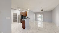 Located at 135 W Elliot Rd in Chandler, AZ, this single-story 2-bedroom, 2-bathroom home offers a well-designed layout with modern finishes throughout. The open-concept living and dining area is anchored by large-format polished marble-look tile flooring that reflects natural light, a ceiling fan, and plantation-shuttered windows and sliding doors that allow for excellent light control and outdoor views.

The kitchen is a functional centerpiece, featuring rich medium-toned wood cabinetry, granite countertops, a mosaic tile backsplash, stainless steel appliances including a refrigerator, range, microwave, and dishwasher, and a peninsula with a built-in sink. An adjacent pantry provides ample additional storage.

The primary bedroom is a comfortable size and includes plantation shutters on both a window and a full glass door, providing natural light and outdoor access. Light wood-look plank flooring adds warmth to both bedrooms. Both bathrooms are finished with matching marble-look tile and feature frameless sliding glass shower enclosures over tub-shower combos with brushed nickel fixtures and granite-topped vanities. A dedicated hallway, closet, and pantry round out the practical layout of this clean, move-in ready Chandler home.