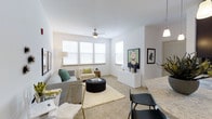 Located at 203 Magnolia Blvd in Port Wentworth, Georgia, this single-floor residence offers a well-designed, open-concept layout that maximizes both comfort and functionality. The living area is bright and airy, bathed in natural light streaming through multiple windows fitted with clean white blinds. Neutral-toned carpet and crisp white walls create a versatile backdrop, while a ceiling fan overhead ensures year-round comfort. The living space is generously proportioned, comfortably accommodating a full seating arrangement with room to spare, and flows naturally into the dining and kitchen areas. The kitchen features granite countertops and is open to the living space, ideal for entertaining or everyday living. Bar-style seating at the kitchen counter further enhances the open, connected feel of the home. The overall ambiance is modern and inviting, characterized by a clean, minimalist aesthetic. Thoughtful details such as contemporary light fixtures and ample wall space for art contribute to a polished, move-in-ready atmosphere. This residence presents a practical yet stylish living environment suited for a wide range of lifestyles.