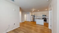 Located on Lacuna Lane in Kissimmee, Florida, this single-floor, 2-bedroom, 2-bathroom home offers a clean, modern design with thoughtful finishes throughout. The open-concept living area features wood-look flooring, a textured ceiling, and a large window that fills the space with natural light, creating a bright and welcoming atmosphere.

The kitchen is a standout feature, equipped with gray shaker-style cabinetry, granite countertops, a full suite of stainless steel appliances including a refrigerator, range, microwave, and dishwasher, and a central island that provides additional prep and dining space. Recessed lighting adds a polished touch to the kitchen and adjacent living area.

Both bedrooms are carpeted for comfort and include windows with blinds that offer views of the surrounding greenery. The primary bedroom is a well-sized retreat with ceiling fan, while the second bedroom features its own ceiling fan and a similarly bright outlook. A dedicated closet provides convenient storage.

The two bathrooms are finished with granite-topped vanities, gray cabinetry with brushed nickel hardware, wood-look tile flooring, and clean white walls. Each bathroom is efficiently laid out with a shower and modern fixtures. The overall palette of neutral whites and warm wood tones gives the home a cohesive, contemporary feel.