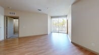 Located at 110 S Hoover Blvd in Tampa, FL, this well-designed 2-bedroom, 2-bathroom residence offers a comfortable and functional single-floor layout. Light wood-style flooring flows throughout the main living areas, complementing the neutral, warm-toned walls that create a bright and inviting atmosphere. The open living room features a large sliding glass door with vertical blinds, allowing abundant natural light and views of the surrounding greenery. The kitchen is outfitted with rich dark wood cabinetry, granite countertops, a tile backsplash, and a full suite of stainless steel appliances including a refrigerator, electric range, and built-in microwave. A dedicated in-unit laundry area adds everyday convenience. Both bedrooms are carpeted and include ceiling fans; the primary bedroom is generously sized and is paired with a private en-suite bathroom featuring a walk-in glass-enclosed shower, granite vanity, and tile flooring. The second bathroom offers a tiled tub-shower combination with a granite vanity and dark wood cabinetry. A spacious walk-in closet with wire shelving provides ample storage. This residence combines practical design with modern finishes in a well-located Tampa neighborhood.