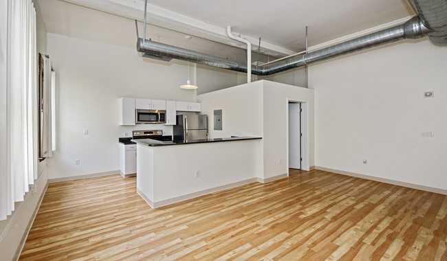 Kitchen features granite countertops, stainless steel appliances and breakfast bar - Bank and Boston Lofts