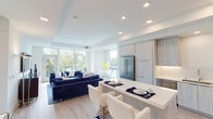Located at 12501 Ridgedale Dr in Minnetonka, Minnesota, this contemporary single-floor residence offers a sleek, open-concept design defined by clean lines, light-toned finishes, and an abundance of natural light. The living area is anchored by expansive floor-to-ceiling windows and a glass-panel balcony door that frames serene waterfront and lush tree-line views, creating a seamless connection between the interior and the natural surroundings outside. Recessed lighting and tray ceilings add architectural dimension throughout the space.

The kitchen is a standout feature, showcasing custom light wood-grain cabinetry that extends to the ceiling, quartz countertops, stainless steel appliances including a gas cooktop, double wall ovens, a built-in refrigerator, and a generous island with bar seating — ideal for both everyday living and entertaining.

The bedrooms are bright and serene, with large windows offering verdant outdoor views and plush carpeting underfoot. The bathroom features a white quartz vanity, backlit mirror, and a glass-enclosed tiled shower, delivering a spa-like aesthetic. Light hardwood flooring flows through the main living areas, tying together the residence's cohesive modern design.