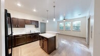 Located at 6480 Watergate Ln in Jacksonville, Florida, this single-floor residence offers a well-organized layout with two bedrooms and two full bathrooms. Light wood-style flooring runs consistently throughout the home, creating a cohesive and clean aesthetic.

The kitchen is a standout feature, equipped with rich dark wood cabinetry, a central island with a white countertop, pendant lighting, black appliances including a refrigerator and range, and a dedicated sink area. The open sightlines from the kitchen connect naturally to the living areas, enhancing the sense of space.

Both bedrooms are bright and airy, each featuring a ceiling fan with light fixture and a window that invites natural light and views of surrounding greenery. The primary bedroom includes a double-door closet and an additional storage closet, offering generous organizational space.

The two bathrooms are thoughtfully appointed with dark wood vanities, marble-style countertops, large mirrors, and wood-style flooring. One bathroom features a tiled tub-shower combination, while the other offers a walk-in shower with classic white subway tile surround. Both include safety grab bars, reflecting a practical and accessible design sensibility.

Overall, the home presents a clean, modern interior with consistent finishes throughout.