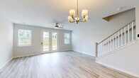 This two-story home in Woodruff, South Carolina offers four bedrooms and four bathrooms across two well-proportioned floors. The main level features an open-concept kitchen and living area with light luxury vinyl plank flooring throughout. The kitchen is a standout, boasting white shaker cabinetry, granite countertops, a center island with a undermount sink, stainless steel appliances, and recessed lighting — an ideal space for cooking and entertaining. The living area flows seamlessly from the kitchen, bathed in natural light with a clean, neutral palette. An attached garage with an automatic opener provides convenient storage and parking. Upstairs, the carpeted bedrooms offer a comfortable retreat, including a generously sized primary bedroom with a ceiling fan, windows overlooking the surroundings, and access to a well-appointed en-suite bathroom featuring a dual-sink vanity with white cabinetry, quartz countertops, and wood-look tile flooring. Additional bedrooms are bright and airy with large windows. A walk-in closet with wire shelving provides ample storage. The home's consistent use of neutral tones, modern finishes, and practical layout creates a welcoming and functional living environment throughout.