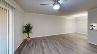 Located at 4204 Trace View Dr in Winston-Salem, NC, this one-bedroom, one-bathroom unit offers a thoughtfully designed single-floor layout across a comfortable footprint. The living room serves as the centerpiece of the home, showcasing wood-look luxury vinyl plank flooring, crown molding, a ceiling fan, and a sliding glass door that fills the space with natural light. Adjacent to the living area, the kitchen is a galley-style space outfitted with white shaker cabinetry, granite-style countertops, stainless steel appliances including a refrigerator and range, and a double basin sink — all framed by matching light flooring. A pass-through opening connects the kitchen to the hallway and dining area, creating an open and connected feel. The hallway leads to the bedroom, which features plush wall-to-wall carpeting, a ceiling fan, a window for natural light, and access to two closets — including a walk-in closet with built-in shelving, offering generous storage. The bathroom is finished with a granite-top vanity, white cabinetry with brushed nickel hardware, a large framed mirror, and contemporary light fixtures. Throughout the unit, neutral tones and consistent finishes create a cohesive, clean aesthetic.