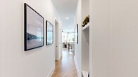 This 1,140 square foot apartment offers a harmonious blend of style and functionality. The open-concept layout features a gourmet kitchen with stainless steel appliances, white cabinetry, and a central island, seamlessly connecting to the dining and living areas. Large windows flood the space with natural light, while wood-look flooring adds warmth throughout.

The primary bedroom, spanning 160 square feet, boasts an en-suite bathroom and a calming blue accent wall. The second bedroom is equally well-appointed, with both rooms featuring ample closet space. Three full bathrooms, finished with modern fixtures and neutral tones, provide convenience and luxury.

The living room is anchored by a sleek entertainment center and adorned with designer lighting. A private balcony offers outdoor space and views of the surrounding landscape. The apartment is part of a contemporary multi-unit complex with well-maintained grounds, parking facilities, and communal areas.

With its thoughtful design, high-end finishes, and prime location, this apartment presents an ideal living solution for those seeking comfort and style in a modern setting.