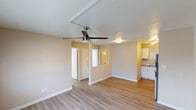 Located at 1010 N 48th St in Phoenix, Arizona, this single-floor unit offers a clean, functional layout designed for comfortable everyday living. The open main living area features light-toned luxury vinyl plank flooring throughout, warm neutral walls, and a ceiling fan that provides both style and airflow — a practical touch well-suited to the Phoenix climate. A wall-mounted HVAC unit ensures year-round climate control, and natural light filters in through blinded windows that offer views of the surrounding neighborhood rooftops.

The kitchen is thoughtfully updated, showcasing crisp white shaker-style cabinetry, a bold white subway tile backsplash, stainless steel appliances including an electric range and over-the-range microwave, and a single-basin sink — delivering a modern, functional cooking space. The bedroom is a quiet, well-proportioned room with its own ceiling fan, continued vinyl plank flooring, and a window dressed with horizontal blinds that allow natural light while maintaining privacy.

The bathroom features a clean, white tub-shower combination with a rainfall-style showerhead and brushed nickel fixtures, set against neutral taupe walls for a simple, timeless finish. Overall, the unit presents a well-maintained, move-in-ready space with consistent modern updates throughout.
