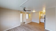 Located at 1010 N 48th St in Phoenix, Arizona, this single-floor unit offers a clean, functional layout designed for comfortable everyday living. The open main living area features light-toned luxury vinyl plank flooring throughout, warm neutral walls, and a ceiling fan that provides both style and airflow — a practical touch well-suited to the Phoenix climate. A wall-mounted HVAC unit ensures year-round climate control, and natural light filters in through blinded windows that offer views of the surrounding neighborhood rooftops.

The kitchen is thoughtfully updated, showcasing crisp white shaker-style cabinetry, a bold white subway tile backsplash, stainless steel appliances including an electric range and over-the-range microwave, and a single-basin sink — delivering a modern, functional cooking space. The bedroom is a quiet, well-proportioned room with its own ceiling fan, continued vinyl plank flooring, and a window dressed with horizontal blinds that allow natural light while maintaining privacy.

The bathroom features a clean, white tub-shower combination with a rainfall-style showerhead and brushed nickel fixtures, set against neutral taupe walls for a simple, timeless finish. Overall, the unit presents a well-maintained, move-in-ready space with consistent modern updates throughout.