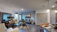 Located on Speer Boulevard in Denver's vibrant Golden Triangle neighborhood, this single-floor residence combines contemporary design with comfortable, functional living. The open-concept layout connects the living, dining, and kitchen areas seamlessly, creating a spacious and cohesive flow throughout.

The living room features rich wood-style flooring, a calming blue accent wall adorned with mountain-inspired artwork, and a mix of seating anchored by a round wood coffee table. Natural light pours in through large windows and a glass door leading to a private outdoor balcony.

The gourmet kitchen is a standout, showcasing light gray flat-panel cabinetry, a textured stone tile backsplash, dark granite countertops, stainless steel appliances, and a large island with dramatic veined stone countertop and pendant lighting overhead — ideal for both cooking and casual dining.

Two well-appointed bedrooms offer plush carpet flooring and ceiling fans. The primary bedroom features a bold dark accent wall with gallery-style artwork and access to a walk-in closet, while the second bedroom benefits from generous natural light through a large window.

The bathroom is finished with large-format tile in the tub surround, a sleek vanity, and classic monochromatic décor. Throughout, the residence maintains a modern, urban aesthetic with thoughtful design details at every turn.