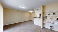 Located on Spencer Hwy in Pasadena, TX, this 1-bedroom, 1-bathroom residence offers a thoughtfully organized single-floor layout designed for comfortable everyday living. The combined kitchen and living room area forms the heart of the home, featuring soft carpeted flooring in the living space and warm beige walls that create a bright, welcoming ambiance. A partial wall with built-in open shelving neatly divides the living area from the kitchen pass-through, adding both style and practicality. The galley-style kitchen is equipped with light wood cabinetry, dark granite-style countertops, tile flooring, and black appliances including a refrigerator, range, and dishwasher, providing ample storage and workspace. The bedroom is generously sized, featuring plush carpeting, a ceiling fan, and a sliding glass door with vertical blinds that opens to an outdoor view, filling the room with natural light. A dedicated closet offers convenient built-in storage. The bathroom features tile flooring, a wide vanity with wood cabinetry and a granite-style countertop, a large mirror, and overhead lighting. Throughout the residence, neutral tones, consistent finishes, and practical design choices combine to create a cohesive and comfortable living environment.