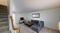 This two-story home in Saint Louis, Missouri offers a practical and comfortable layout across two well-proportioned floors. The main level is anchored by a welcoming living room featuring plush carpeting, neutral white walls, and a window that draws in natural light. The kitchen is a standout feature, equipped with warm honey-toned cabinetry, a central island with a built-in cooktop, a striking copper range hood, exposed brick backsplash accents, and ample counter and storage space — all complemented by easy-care hardwood-style flooring. The upper level houses both bedrooms, each carpeted and finished with clean white walls. The spacious primary bedroom benefits from natural light through a window and features a large sliding-door closet. The second bedroom is similarly comfortable, also offering closet storage and a window with outdoor views. The full bathroom includes a tub-shower combination with tiled surround, a single-sink vanity with a large mirror, and wood-toned cabinetry. A hallway connects the upper-level rooms efficiently. Throughout the home, the design maintains a clean, understated aesthetic with consistent neutral tones, making for a cohesive and move-in-ready living environment.
