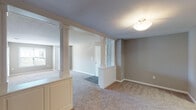 Located at 7011 W Friendly Ave in Greensboro, NC, this single-story home offers a well-designed layout with a range of functional and architectural details throughout. The entry foyer makes a notable first impression, framed by decorative fluted columns and a half-wall partition that elegantly define the transition into the main living areas. Neutral-toned carpet flows throughout the living spaces and bedrooms, contributing to a warm, cohesive atmosphere.

The kitchen is outfitted in a classic U-shaped configuration, featuring white cabinetry, granite-look countertops, a full suite of black appliances including a refrigerator, range, microwave, and dishwasher, and wood-look flooring that adds a clean contrast to the cabinetry. Two bathrooms serve the home: one includes a tub-shower combination, while the other features a walk-in shower with a decorative curtain and wood-look flooring. Both are finished with white vanities and standard fixtures.

The bedrooms are generously proportioned, each with plush carpet, neutral walls, and windows providing natural light. At least one bedroom benefits from a walk-in closet with wire shelving for organized storage. A dedicated laundry area accommodates a full-size washer and dryer with overhead shelving, adding everyday convenience to the home.