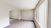 Located at 16 Hampshire Heights in Northampton, MA, this two-story, 2-bedroom, 1-bathroom home offers a well-organized layout with living space evenly divided between two floors. The main level features a bright living room with large windows fitted with vertical blinds that invite generous natural light, along with light-toned luxury vinyl plank flooring that flows throughout. The adjacent dining room is accented by a decorative chandelier and a window overlooking the outdoors. The kitchen has been updated with crisp white cabinetry, white quartz-style countertops, stainless steel appliances including a gas range and over-the-range microwave, and a window above the sink. A stacked washer and dryer unit is conveniently located within the kitchen area. Upstairs, the spacious primary bedroom features plush carpet, a large closet, a wide window with vertical blinds, and wall-unit climate control. The second bedroom is also carpeted and features neutral tones. The full bathroom includes a vanity with mirror, a tub-shower combination, and a natural light window. Throughout the home, neutral gray walls and clean white trim create a consistent, move-in-ready aesthetic.