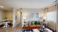 Located at 3325 Oak Forest Dr in Fayetteville, NC, this single-floor residence offers a thoughtfully designed layout with a warm, cohesive aesthetic throughout. The living area is bright and inviting, featuring wood-look flooring, crown molding, and access to an outdoor patio through sliding glass doors that bring in natural light. The space is well-proportioned, providing a comfortable setting for both relaxing and entertaining.

The kitchen is efficiently laid out with white cabinetry, subway tile backsplash, a undermount sink, and wood-look flooring that extends seamlessly through the common areas. Ample counter space and storage make it highly functional. Adjacent to the kitchen, a charming dining nook features built-in bench seating with wainscoting detail and a decorative arched mirror, creating an intimate dining experience.

The bedrooms offer plush carpeting, natural light through window blinds, and generous proportions. The primary bedroom is particularly spacious, accommodating a large bed and dresser with ease, while a secondary bedroom provides a comfortable retreat. The bathroom is clean and bright, outfitted with white cabinetry, a full tub-shower combination with a curved curtain rod, and a well-lit vanity mirror. Crown molding and neutral tones tie together the home's inviting, contemporary character.
