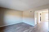 Located at 3200 Desert Dr in East Point, GA, this two-story, 2-bedroom, 2-bathroom home offers a practical and comfortable layout spread across two floors. The main level features two distinct living areas, providing flexible space for lounging or dining, both finished with durable wood-style plank flooring in a cool gray tone. Natural light filters in through windows, brightening the neutral, warm-beige walls that carry throughout the home. The galley-style kitchen is well-appointed with rich warm-toned wood cabinetry, ample counter space, granite-style countertops, and full appliances including a stainless steel refrigerator, electric range, and dishwasher. A dedicated laundry area with washer and dryer hookups adds everyday convenience. Carpeted staircases lead to the upper floor, where both bedrooms are located. The generously sized primary bedroom includes an en-suite bathroom, while the second bedroom offers comfortable proportions and easy access to the second full bathroom. Each bedroom features plush carpet flooring and textured ceilings. Both floors include closet storage, ensuring ample organization throughout. The home's clean, neutral palette and functional design make it a move-in ready residence in East Point.