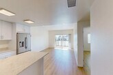 Located at 6830 Cortona Dr in Goleta, California, this modern 1-bedroom, 1-bathroom unit offers a thoughtfully designed open-concept layout finished with light wood-look flooring and crisp white walls throughout. The living room is bright and welcoming, anchored by a sliding glass door that opens to a private balcony overlooking the surrounding neighborhood, filling the space with abundant natural light. Recessed lighting complements the airy atmosphere throughout the main living area.

The kitchen is a standout feature, showcasing white shaker-style cabinetry extending to the ceiling, light stone quartz countertops, and a central island that provides additional prep and seating space. Stainless steel appliances include a gas range, built-in microwave, dishwasher, and a French door refrigerator with an ice and water dispenser.

The bedroom is a comfortable, well-proportioned retreat with a window fitted with blinds for natural light and privacy, complemented by a dedicated closet. The full bathroom features wood-look flooring, a vanity with dark countertop, and a combined tub and shower enclosed with a glass sliding door. Clean lines and a neutral palette create a cohesive, modern aesthetic throughout this efficiently laid-out Goleta residence.