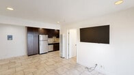 Located at 6656 Picasso Rd in Goleta, CA, this one-bedroom, one-bathroom unit offers a thoughtfully designed single-floor layout. The kitchen is a standout feature, showcasing rich dark-wood cabinetry, granite countertops, a neutral stone tile backsplash, and a full suite of stainless steel appliances including a gas range, built-in microwave, dishwasher, and refrigerator. Recessed lighting illuminates the space, and large-format beige tile flooring extends throughout, creating a cohesive and easy-to-maintain finish. The open view from the living area into the kitchen highlights the functional layout and clean design. The bedroom is a comfortable, well-proportioned room featuring a ceiling fan, a generous window that invites natural light, and the same tile flooring for continuity. The bathroom is elegantly appointed with a glass-enclosed walk-in shower clad in multi-toned travertine-style tile set in a diagonal pattern, complemented by mosaic tile flooring and oil-rubbed bronze fixtures that add a refined touch. A wall-mounted heating unit provides climate control. Overall, the unit presents a clean, modern aesthetic with quality finishes throughout, ideally situated near the University of California, Santa Barbara.