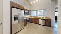 Located at 9380 Quadrangle St, Unit 102 in Lorton, VA, this two-bedroom, two-bathroom residence offers a thoughtfully designed single-floor layout. The kitchen is a standout feature, showcasing rich dark-wood cabinetry, granite countertops, and a full suite of stainless steel appliances including a French door refrigerator with ice maker, electric range, built-in microwave, and dishwasher. Soaring ceilings and an exposed brick accent wall add industrial character, while a window provides natural light and exterior views.

Both bedrooms are carpeted and generously proportioned, with the primary bedroom boasting impressively tall ceilings, a double-door closet, and abundant natural light filtering through the windows. The second bedroom also features large windows fitted with blinds, filling the room with daylight. Two hallways connect the living spaces efficiently throughout the unit.

The bathrooms offer clean, functional designs: one features a walk-in shower with chrome fixtures and wood-look tile flooring, while the second includes a full soaking tub and shower combination. The overall aesthetic is bright, neutral, and move-in ready, with a clean palette of whites and warm beiges throughout.
