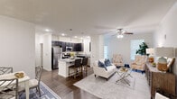 This single-story residence in Lafayette, Louisiana, offers a thoughtfully designed open-concept layout that seamlessly connects the kitchen, dining, and living areas. Dark hardwood-style flooring runs throughout, providing a striking contrast against the crisp white walls and crown molding that frame each room.

The kitchen is a standout feature, equipped with dark espresso cabinetry, stainless steel appliances, granite countertops, and a central island with bar seating — ideal for both casual dining and meal preparation. The adjoining living room is bright and welcoming, highlighted by a ceiling fan and natural light from large windows with plantation shutters. A separate dining room provides a defined space for formal meals, accented by recessed lighting and crown molding.

The primary bedroom offers comfortable proportions with direct access to a walk-in closet fitted with wire shelving and a private bathroom featuring a tiled walk-in shower and granite vanity. Additional bedrooms share well-appointed bathrooms. A dedicated laundry room with a full-size washer and dryer adds everyday convenience, completing this efficiently organized home.