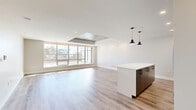 Located at 1452 Brenton Street in downtown Halifax, this modern 2-bedroom, 2-bathroom unit offers a thoughtfully designed open-concept layout with high-end finishes throughout. The living area is bright and expansive, featuring light hardwood flooring, recessed lighting, and striking floor-to-ceiling windows that flood the space with natural light. A distinctive exposed concrete ceiling detail adds an industrial-chic element to the living room, which opens directly to a generous terrace offering panoramic views of the Halifax skyline.

The kitchen is a standout, equipped with dark wood cabinetry extending to the ceiling, a tiled backsplash, stainless steel appliances, and a large white quartz island with pendant lighting — ideal for both cooking and entertaining. Both bedrooms are well-proportioned with large windows framing urban views and are complemented by dedicated closets. The two bathrooms are finished in a clean, contemporary style, with one featuring a full walk-in glass shower with white subway tile surround and a lighted mirror. Additional conveniences include in-unit laundry. This residence combines modern urban design with practical functionality in the heart of Halifax.