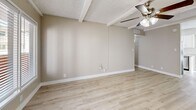 Located at 6201 N 16th St in Phoenix, AZ, this well-appointed one-bedroom, one-bathroom unit offers a thoughtfully designed single-floor layout. Light wood-look flooring flows consistently throughout the space, complementing the warm neutral tones on the walls and crisp white trim.

The living room is bright and welcoming, featuring a ceiling fan with light kit, exposed beam detailing on the textured ceiling, and a large sliding glass door that draws in natural light and provides outdoor access. The open layout connects seamlessly to the kitchen, which stands out as a highlight of the unit. It is equipped with stainless steel appliances — including a refrigerator, range, microwave, and dishwasher — white shaker-style cabinetry, quartz-style countertops, a subway tile backsplash, and a window above the sink for added brightness.

The bedroom is a comfortable, quiet retreat with its own ceiling fan, a window with blinds, and a closet. The hallway connecting the rooms also features an in-unit stacked washer and dryer, adding everyday convenience. The bathroom includes a vanity with white cabinetry and a light countertop. Throughout the unit, the cohesive design choices — neutral walls, consistent flooring, and clean finishes — create a calm, move-in-ready atmosphere.