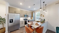 Located in Lawrenceville, GA, this one-bedroom, one-bathroom residence offers a well-appointed single-floor layout designed for comfortable, modern living. The open-concept kitchen serves as a central highlight, featuring light wood cabinetry extending to the ceiling, granite countertops, stainless steel appliances, and a peninsula island with pendant lighting — ideal for both cooking and casual dining. Wood-style flooring runs through the main living areas, adding warmth and continuity throughout the space. The entry hallway makes a strong first impression, lined with recessed lighting and dark-paneled doors that lend a contemporary contrast to the crisp white walls. The bedroom is a serene retreat, complete with plush carpet, a ceiling fan, and a closet for dedicated storage. The bathroom maintains the same refined aesthetic, showcasing a granite-topped vanity with wood cabinetry, dark hardware accents, and wood-style flooring. Natural light filters through multiple windows, brightening each room and creating an inviting ambiance. The cohesive design palette — neutral tones, modern fixtures, and quality finishes — gives this residence a clean, polished feel throughout.