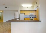 Located at 12325 SW 151st Street in Miami, FL, this single-floor residence offers a clean, functional layout filled with natural light throughout. The entry hallway features light ceramic tile flooring and textured ceilings, leading into an open living area with large sliding glass doors fitted with vertical blinds that invite abundant natural light and provide outdoor access.

The kitchen is designed in a galley style with warm yellow cabinetry, dark countertops, a tiled backsplash, and white appliances including a refrigerator, electric range, and built-in microwave. A pass-through counter connects the kitchen to the living area, enhancing the open feel of the space.

The bedrooms feature smooth light-toned hardwood-style flooring, neutral walls, and windows with blinds offering views of greenery outside. Ceiling fans with integrated lighting fixtures are present, contributing to comfort throughout the year.

The bathrooms are well-appointed, with one featuring a tub-shower combination surrounded by earth-toned tile and yellow cabinetry with a single vanity sink. A second bathroom offers a glass-enclosed walk-in shower, a dual-sink vanity with a wide mirror, and warm tile detailing.

A dedicated in-unit laundry area accommodates a full-sized washer and dryer, adding everyday convenience. The overall ambiance is bright, neutral, and move-in ready.