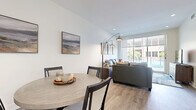 Located at 5315 E High St in Phoenix, Arizona, this well-appointed 3-bedroom, 2-bathroom residence offers a thoughtfully designed single-floor layout with modern finishes throughout. The open-concept living, dining, and kitchen area forms the heart of the home, where light wood-style flooring and neutral tones create a clean, contemporary ambiance. The living room features floor-to-ceiling windows and a sliding glass door that opens to a private balcony, flooding the space with natural light and providing views of the surrounding landscape. The kitchen is outfitted with dark espresso cabinetry, stainless steel appliances, a large white quartz island with bar seating, and pendant lighting — equally suited for cooking and entertaining. The dining area offers an intimate setting complemented by tasteful wall art. The spacious primary bedroom enjoys expansive windows with outdoor views and ample natural light, while additional bedrooms are comfortably sized. Three closets provide generous storage throughout. The primary bathroom features a glass-enclosed walk-in shower with large-format tile, while the second bathroom includes a full tub-shower combination. In-unit laundry and recessed lighting complete this polished, move-in-ready residence.