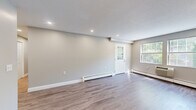 Located at 4 Olde Derby Road in Norwood, MA, this single-floor home offers four bedrooms, two bathrooms, and a thoughtfully designed layout ideal for comfortable living. The open living room is bright and welcoming, featuring durable hardwood-style flooring, recessed lighting, a textured ceiling, and baseboard heating. Natural light filters in through multiple windows, including a charming glass-panel entry door that adds character to the space. The kitchen is a standout feature, outfitted with white shaker cabinets, dark granite countertops, a subway tile backsplash, and a full suite of stainless steel appliances including a range, dishwasher, microwave, and refrigerator. The bedrooms are carpeted for warmth and comfort, with several featuring ample closet space, including a spacious walk-in closet with wire shelving. Both bathrooms are finished with neutral large-format tile and white vanities. One bathroom offers a soaking tub with tiled surround, while the second features a neo-angle glass-enclosed shower. A central hallway connects the rooms efficiently, and two dedicated closets provide additional storage throughout the home.