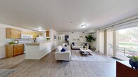 Located at 368 S Mall Dr in St. George, Utah, this single-floor, 3-bedroom, 1-bathroom unit offers a well-designed layout that maximizes its comfortable footprint. The open-concept main living area seamlessly connects the living room, dining area, and kitchen, creating a bright and cohesive space. Light wood-style flooring flows throughout the main area, complementing the neutral white walls and contributing to an airy, clean aesthetic.

The kitchen features warm-toned natural wood cabinetry, white appliances including a gas range and refrigerator, and a peninsula breakfast bar that opens to the living and dining spaces — ideal for everyday functionality. The dining area accommodates a full table and is accented by stylish wall décor.

The living room is generously sized, offering ample room for multiple seating arrangements, and includes a sliding glass door that leads to a private patio with outdoor views, allowing natural light to fill the space.

The primary bedroom is notably spacious, featuring plush carpeting for added comfort. Two additional bedrooms provide flexible options for roommates, guests, or a home office. The full bathroom includes a single-sink vanity with wood cabinetry and a shower/tub combination. A dedicated laundry room with washer and dryer hookups rounds out the practical features of this well-appointed unit.
