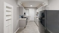 Located at 5345 Cabanne Ave in St. Louis, MO, this 3-bedroom, 1-bathroom residence offers a thoughtfully designed single-floor layout. The unit is finished with light hardwood-style flooring throughout, paired with neutral gray walls and crisp white trim and baseboards, creating a clean, cohesive aesthetic in every room.

The living area makes a strong first impression with an arched entryway, decorative wall molding panels, and an arched front door that adds architectural character. Multiple windows flood the space with natural light and provide views of the surrounding greenery, contributing to an airy, open ambiance.

The galley-style kitchen is well-appointed with gray shaker cabinets, granite-look countertops, a tile backsplash, and black appliances including a gas range and full-size refrigerator. A window above the sink brings in additional natural light.

The primary bedroom is generously sized, featuring an arched window, a standard window, and a sliding glass door that opens to the outdoors. The additional bedrooms are comfortably proportioned, each with closet access and neutral finishes. A central hallway connects the bedrooms to the shared full bathroom, which includes a vanity with a white countertop. The layout is efficient and functional, making excellent use of the available space.