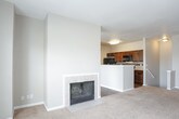 This single-story residence offers a thoughtfully designed layout with a neutral color palette of warm beige tones that flows consistently throughout the space. The open living area serves as the heart of the home, anchored by a tile-surround fireplace and expansive windows that invite generous natural light. The space connects directly to the kitchen, which features dark espresso cabinetry, light countertops, wood-look vinyl flooring, and black appliances including a refrigerator and dishwasher. A breakfast bar peninsula provides additional workspace and casual seating.

The bedrooms are carpeted in plush, light-toned carpet and each include ceiling fans and walk-in closets with built-in shelving and hanging rods. Windows in each bedroom offer outdoor views, enhancing the sense of openness. White panel doors and clean white baseboards add a crisp contrast to the warm wall tones throughout.

The bathrooms feature warm wood-look vinyl flooring, dark espresso vanity cabinetry, light countertops, large mirrors, and tub-shower combinations. Clean lines and consistent finishes give the bathrooms a functional yet polished appearance. Overall, the space presents a cohesive, move-in-ready aesthetic with practical features distributed evenly across the floor plan.