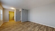 This single-floor unit at 6221 East 36th Street in Tulsa, Oklahoma, offers a well-organized layout with thoughtfully updated finishes throughout. The living area is generously sized, featuring durable wood-look plank flooring and neutral gray walls that create a clean, contemporary backdrop. Natural light filters in through a window fitted with blinds, complementing the open feel of the space.

The galley-style kitchen is efficiently arranged with white shaker cabinetry, granite-look countertops, a stainless steel sink, and black appliances including an electric range, refrigerator, and dishwasher. An under-cabinet range hood and wood-look flooring complete the kitchen's practical design.

The bedroom features plush carpeting, a ceiling fan with light fixture, a window with blinds for natural light, and a spacious double-door closet with built-in rods and shelving, providing ample storage.

The bathroom is well-appointed with white cabinetry, a granite-look vanity countertop, wood-look tile flooring, and a full tub-shower combination finished with marble-look tile surround. A textured accent wall adds visual interest to the space.

Throughout the unit, consistent trim work, updated fixtures, and a cohesive neutral color palette contribute to a clean, move-in-ready ambiance.