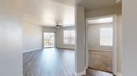 Located at 8120 Mainland Dr in San Antonio, Texas, this single-floor residence offers a practical and comfortable layout with two bedrooms and two full bathrooms. The open living area is bright and welcoming, featuring wood-look laminate flooring, neutral gray walls, and a ceiling fan that enhances airflow throughout the space. Large windows and a sliding glass door flood the room with natural light and provide direct access to a private patio with outdoor views.

The kitchen is designed for functionality, featuring white cabinetry, stone-look countertops, stainless steel appliances including a refrigerator and electric range, a double-basin sink, and a pass-through counter that connects seamlessly to the living area. A dedicated in-unit laundry area adds everyday convenience.

Both bedrooms are carpeted for comfort, each equipped with a ceiling fan, generous closet space with bifold doors, and ample room for furnishings. The primary bedroom is well-proportioned, offering its own access to a full bathroom. The bathrooms are finished with wood-look flooring, stone-look countertops, white cabinetry, and tub-shower combinations. A hallway connects the key areas of the home, contributing to a cohesive and efficient floor plan throughout.
