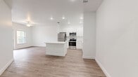 Located at 2089 Heritage Key Blvd in Kissimmee, FL, this single-floor, one-bedroom, one-bathroom unit offers a well-designed layout with a clean, modern aesthetic throughout. The open-concept living and kitchen area is bright and airy, finished with light wood-look flooring and crisp white walls that lend a fresh, contemporary feel. The kitchen is well-equipped with white shaker-style cabinetry, a full suite of stainless steel appliances including a refrigerator, range, and microwave, and a central island that provides additional prep and storage space. Recessed lighting illuminates the kitchen and living areas effectively. The living area features a ceiling fan and glass doors that open to a private balcony, allowing natural light and outdoor views to fill the space. The bedroom is a comfortable size, fitted with a ceiling fan and a large window overlooking greenery, and connects directly to the full bathroom. The bathroom features a vanity with white cabinetry and a bathtub with shower. A dedicated walk-in closet with built-in wire shelving provides organized storage. An in-unit laundry area with a full-size washer and dryer adds everyday convenience. The unit's consistent light flooring, white trim, and neutral palette create a cohesive, move-in-ready environment.