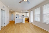 Located in Longwood, FL, this well-appointed 2-bedroom, 2-bathroom residence offers a thoughtfully designed open-concept floor plan. The combined living, dining, and kitchen area serves as the heart of the home, featuring light wood-tone flooring, recessed lighting, and a ceiling fan. The kitchen is a standout space, equipped with stainless steel appliances, a white subway tile backsplash, dual-tone cabinetry pairing crisp white upper cabinets with warm wood lower cabinets, and a large island with quartz countertops topped by pendant lighting. A bright corner area with multiple windows fitted with white blinds allows generous natural light to fill the space. Both bedrooms are carpeted and generously sized, with the primary bedroom offering ample room. Three closets, including a walk-in with wire shelving, provide excellent storage. The bathrooms feature wood-toned vanities with quartz countertops, modern fixtures, and tub-shower combinations. A dedicated laundry area and three well-placed closets add practicality. The private balcony offers open views of the surrounding greenery and skyline, completing this clean, contemporary residence.