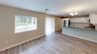 Located at 2019 Eastcastle Dr SE in Grand Rapids, Michigan, this single-floor home presents a clean, modern aesthetic with a thoughtfully designed open-concept layout. The interior is finished in a cohesive neutral palette of warm beiges and crisp whites, creating a bright and welcoming atmosphere throughout.

The kitchen serves as a centerpiece of the home, featuring white shaker-style cabinetry that extends to the ceiling for generous storage, gray quartz-style countertops, a classic white subway tile backsplash, and a full suite of stainless steel appliances including a refrigerator, range, microwave, and dishwasher. A breakfast bar provides additional prep and seating space, while pendant lighting adds a polished finishing touch.

The open living and dining area flows naturally from the kitchen and is finished with light wood-look luxury vinyl plank flooring. A sliding glass door and large windows invite ample natural light and outdoor access. The bedrooms are carpeted for comfort and include windows with blinds.

Two bathrooms serve the home: one featuring a tub-shower combination with a white vanity and gray countertop, and a second with a walk-in shower, wood-look flooring, and brushed nickel fixtures. Closet storage is also available within the living areas, rounding out this well-appointed, move-in-ready home.