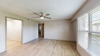 Located at 3700 Curry Ford Rd in Orlando, FL, this single-story 2-bedroom, 2-bathroom unit offers a well-organized layout designed for comfortable everyday living. Light wood-style flooring runs throughout the main living areas, complemented by neutral-toned walls and textured ceilings with ceiling fans in the living room and bedrooms for year-round comfort. The living room is bright and open, with a large window that invites natural light and provides outdoor views. The combined kitchen and dining area is a functional highlight, featuring white upper cabinetry, gray lower cabinets, granite countertops, stainless steel appliances including a refrigerator, dishwasher, range, and microwave, along with a skylight that brightens the space. Both bedrooms are well-sized with built-in closets and natural light from windows. The primary bedroom includes ample closet storage. The two bathrooms differ in style — one features a full soaking tub with a window, while the other offers a tiled walk-in shower with a pedestal sink. A hallway connects the rooms efficiently, and four closets throughout provide generous storage. The unit also includes a private patio, adding valuable outdoor space.