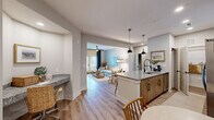 Located at 4711 Azalea Landing Dr in Wilmington, NC, this well-appointed 2-bedroom, 2-bathroom single-floor residence offers a thoughtfully designed open-concept layout with a warm coastal aesthetic throughout. Light wood-tone flooring flows seamlessly across the main living areas, complementing the soft neutral palette on the walls.

The kitchen is a standout feature, showcasing granite countertops, a large island with seating, warm wood cabinetry, stainless steel appliances, and stylish pendant lighting. It opens directly into the dining area and living room, creating an ideal space for entertaining. The dining nook sits adjacent to the entry, offering an intimate setting.

The living room is bright and inviting, with a ceiling fan and access to natural light through sliding doors. Both bedrooms are comfortably sized, featuring large windows that bring in generous natural light, ceiling fans, and ample closet space. The primary bedroom includes an en-suite bath with a dual-sink granite vanity, wood cabinetry, black hardware accents, and a walk-in tiled shower. The second bathroom offers a tub-shower combination with subway tile surround and a matching granite vanity.

A dedicated in-unit laundry room with overhead shelving adds everyday convenience. The coastal-inspired décor and quality finishes throughout lend this residence a polished, move-in-ready appeal.