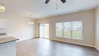 Located at 8 John Maries Way in Rochester, NY, this single-floor home offers a well-designed layout with a bright, open feel throughout. The living and dining areas are finished with light-toned luxury vinyl plank flooring that extends across the main living spaces, complemented by neutral walls and clean white trim. A ceiling fan with a textured ceiling adds character to the main living area, which is bathed in natural light from large windows and a sliding glass door that opens directly to the outdoors, providing views of the surrounding greenery.

The kitchen is thoughtfully appointed with crisp white shaker-style cabinetry, granite countertops, a stainless steel sink, and a full suite of stainless steel appliances including a refrigerator, electric range, and over-the-range microwave. Light hardwood-style flooring ties the kitchen seamlessly into the rest of the home.

The bedrooms feature plush wall-to-wall carpeting and ample natural light from well-positioned windows. Each bedroom offers a calm, neutral palette ideal for comfortable living. Multiple interior doors, including classic six-panel designs, connect the rooms throughout the home, while the overall floor plan provides a practical and efficient single-level layout suited for everyday living.