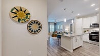 Located at 3030 Ascend Oak St in Apopka, FL, this thoughtfully designed 2-bedroom, 2-bathroom residence offers a comfortable and modern living experience across a single floor. The open-concept layout connects the kitchen and living room seamlessly, creating an inviting communal space. The kitchen is outfitted with crisp white shaker cabinetry, gray quartz countertops, stainless steel appliances including a range, over-the-range microwave, and dishwasher, complemented by a tile backsplash and a breakfast bar with pendant lighting. The living room features warm wood-look flooring, a ceiling fan, large windows, and direct access to an outdoor balcony, filling the space with natural light. The generously sized primary bedroom includes a ceiling fan, ample natural light, and access to a spacious walk-in closet with built-in wire shelving. The second bedroom is equally well-lit with a large window. Both bathrooms are finished with white cabinetry, gray countertops, and wood-look flooring, with the primary bath offering a long vanity. Wood-look flooring flows consistently throughout the home, tying the spaces together with a clean, cohesive aesthetic.