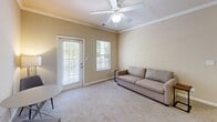 Located at 5605 Holly Grove Way in Knoxville, Tennessee, this one-bedroom, one-bathroom residence offers a well-organized, single-floor layout designed for comfortable everyday living. The living room is a bright, welcoming space featuring warm neutral tones, carpet flooring, crown molding, a ceiling fan, and a glass door that opens to an outdoor balcony, allowing natural light to fill the room. A secondary window further enhances the airy feel of this space.

The kitchen is efficiently designed with warm wood cabinetry, granite-style countertops, tile flooring, and black appliances including an electric range, microwave, dishwasher, and refrigerator. A peninsula counter adds additional workspace and separation from the main living area.

The bedroom offers a comfortable and calm retreat, carpeted throughout, with a ceiling fan, natural light from a window with outdoor views, and direct access to a dedicated closet. The full bathroom is finished with tile flooring, a vanity with storage, and a shower-tub combination. Completing the unit is a dedicated laundry room housing a full-sized Whirlpool washer, with overhead shelving for added storage convenience.