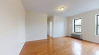 Located at 2 Osborne Terrace in Newark, NJ, this two-bedroom, one-bathroom residence offers a straightforward and functional layout across a single floor. Warm-toned hardwood flooring runs throughout the main living areas and bedrooms, lending a consistent and inviting character to the space.

The spacious primary bedroom is among the most notable features, offering ample room and two large windows that frame outdoor views of the surrounding neighborhood, while a classic cast-iron radiator provides efficient heating. The second bedroom also benefits from natural light through a dedicated window and its own radiator unit. Both rooms are finished with clean white walls and six-panel doors.

The bathroom is well-appointed with warm beige tilework lining the tub-shower surround, a white vanity with sink, and a frosted privacy window. The kitchen features light wood cabinetry, dark countertops, a gas range, and tile flooring, with a window offering views of the streetscape below.

A connecting hallway links the rooms efficiently, contributing to the home's logical flow. Throughout, the neutral color palette and consistent finishes create a clean, move-in-ready environment. The building's traditional architectural character is evident in details such as the deep window casings and radiator heating system, reflecting the classic construction style of the Newark area.