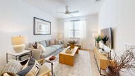 Located at 7733 Burleson Road in Austin, TX, this thoughtfully designed 2-bedroom, 3-bathroom home delivers a clean, contemporary aesthetic throughout its single-floor layout. The living room greets you with warm natural light streaming through large windows dressed in sheer white curtains, complemented by light wood flooring, a ceiling fan, and an inviting, open atmosphere. The kitchen is a standout feature, boasting white shaker cabinetry, a central island with a light countertop, stainless steel appliances, and eye-catching gold pendant lights that add a modern touch. In-unit laundry is conveniently tucked nearby. The primary bedroom is a comfortable retreat with plush carpeting, natural light, a ceiling fan, and direct access to a dedicated walk-in closet equipped with built-in shelving and hanging rods. The second bedroom mirrors the same warm, airy feel. Both closets offer practical storage solutions. The bathrooms are finished in crisp white, featuring subway-tiled tub-shower combinations, wood-look flooring, white vanities with clean countertops, and recessed lighting, creating a spa-like sense of calm. The overall ambiance is bright, neutral, and welcoming — ideal for modern living in the heart of Austin.