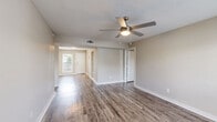 Located at 4000 W 34th St in Houston, TX, this single-story home offers three bedrooms, three bathrooms, a dedicated dining room, and a living room — all unified by warm wood-look flooring throughout. The open living area welcomes natural light through large windows and features a ceiling fan, creating a bright, comfortable atmosphere. The galley-style kitchen is thoughtfully updated with white shaker cabinets, quartz countertops, a subway tile backsplash, stainless steel appliances including a refrigerator and dishwasher, and a single-basin sink. Each of the three bedrooms is equipped with a ceiling fan and window, offering natural light and airflow. The primary bedroom connects to a well-appointed bathroom featuring a wide vanity with quartz countertops, white cabinetry, and generous mirror space. The bathrooms are finished with tiled tub-shower combos accented by decorative mosaic tile borders. Four closets provide ample storage, including a spacious walk-in closet with built-in shelving and hanging rods. A dedicated laundry area and hallway round out the well-organized layout. Neutral wall tones and consistent flooring tie the home together with a clean, modern aesthetic.