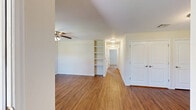 Located at 2000 W Warner Ave in Guthrie, Oklahoma, this single-story, 2-bedroom, 2-bathroom home offers a practical and comfortable layout throughout. Wood-look flooring runs consistently across the entire space, lending warmth and visual cohesion to every room.

The combined kitchen and living area serves as the functional heart of the home. The kitchen features rich dark cabinetry with ample upper and lower storage, light countertops, a double-basin sink, and black appliances including a refrigerator and gas range. A skylight-style ceiling fixture provides bright overhead illumination, complemented by a window that brings in natural light.

The living room is open and well-proportioned, featuring a ceiling fan with light kit and a large window that frames views of the surrounding neighborhood. Both bedrooms continue the warm flooring aesthetic and include ceiling fans, windows with blinds for natural light and privacy, and generous wall space. The primary bedroom benefits from a dedicated closet with built-in shelving. One bedroom also features built-in wall shelving, adding useful display and storage space.

The two bathrooms are cleanly finished with dark vanity cabinetry, light countertops, and wood-look flooring. One bathroom includes a walk-in shower with tile surround, built-in corner shelving, grab bars, and a wall-mounted storage cabinet, reflecting a thoughtfully accessible design.
